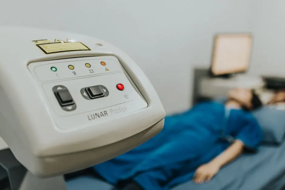 Medical examination setting with patient lying on bed, focus on healthcare device.